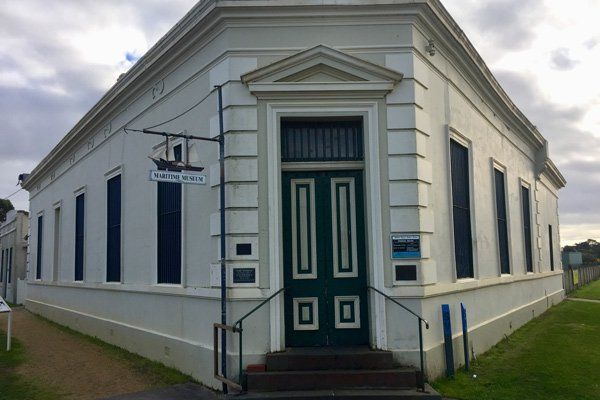 A white building with a green door and stairs