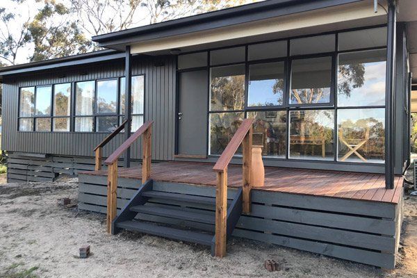 A small house with a wooden deck and stairs
