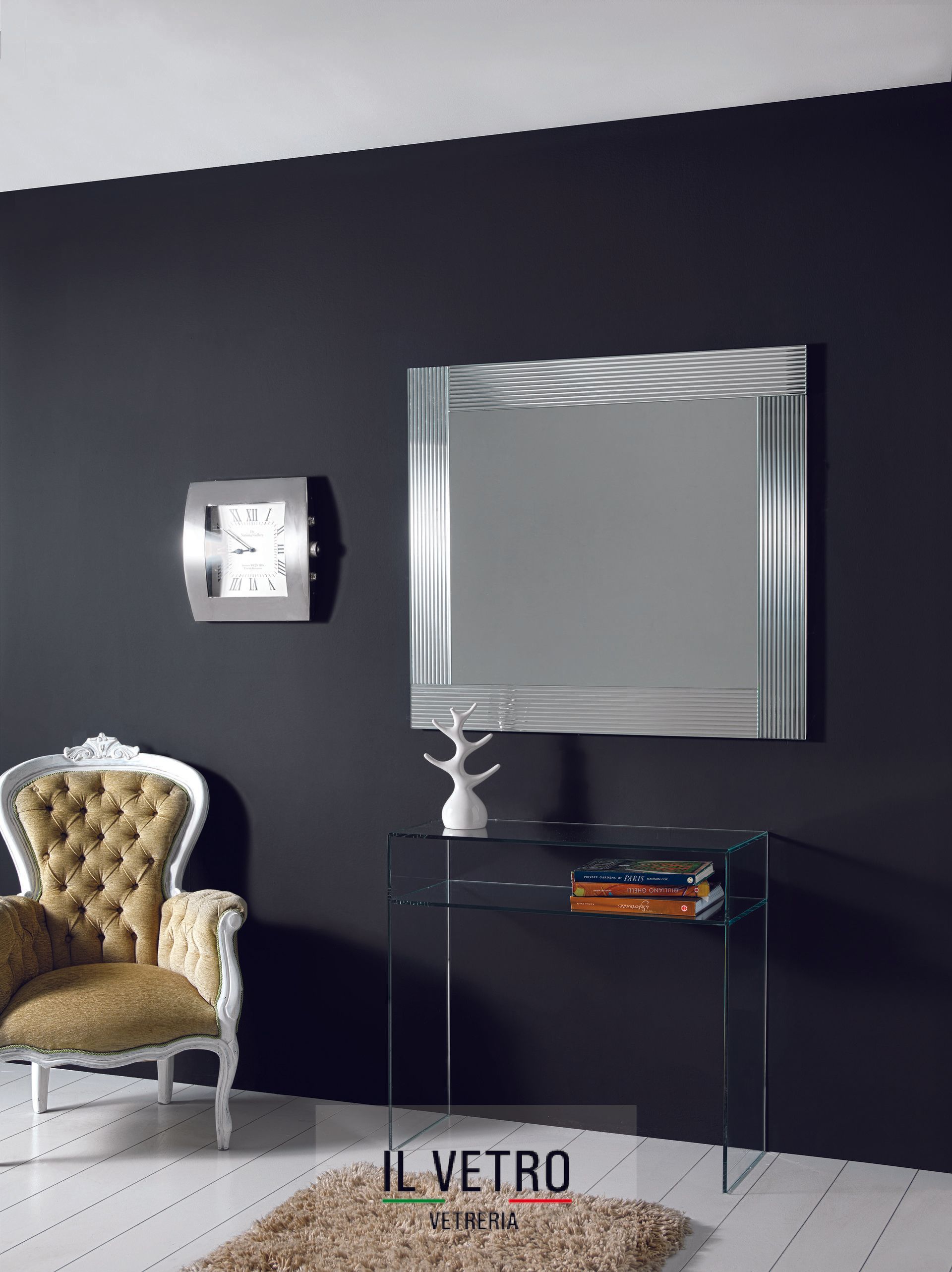 sala con una poltrona, scrivania in vetro e parete attrezzata in vtero