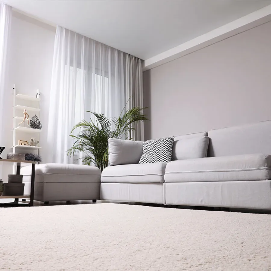 A living room with a white couch and ottoman