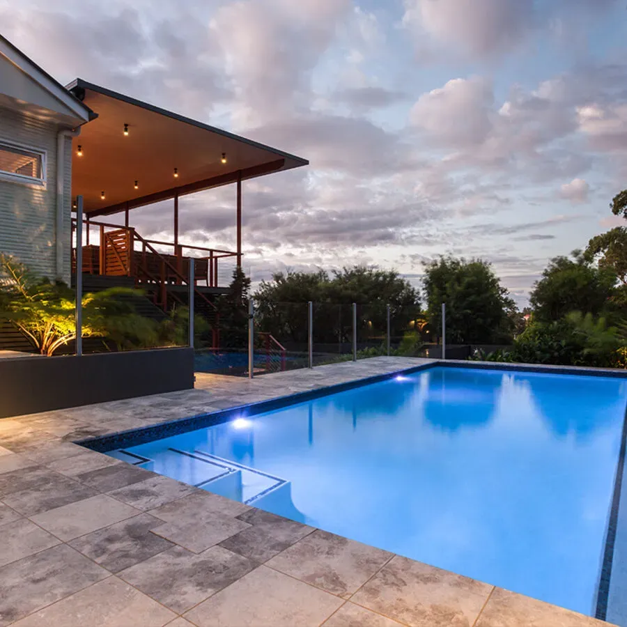 A house with a large swimming pool in front of it