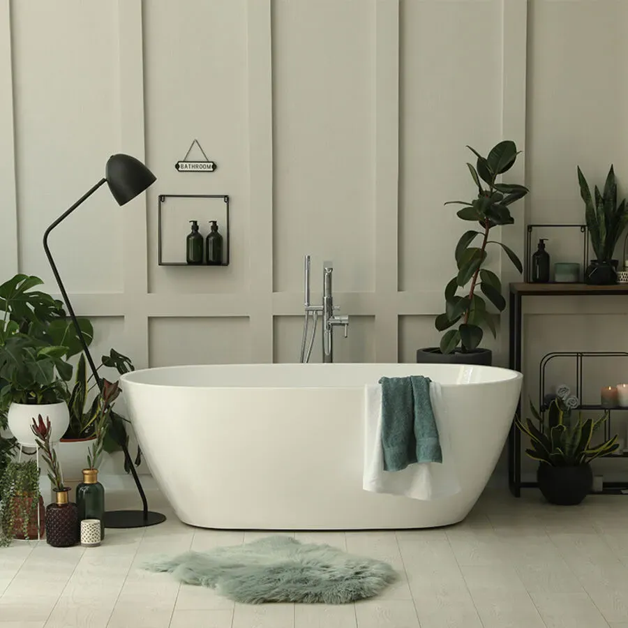 A bathroom with a bathtub surrounded by plants and candles