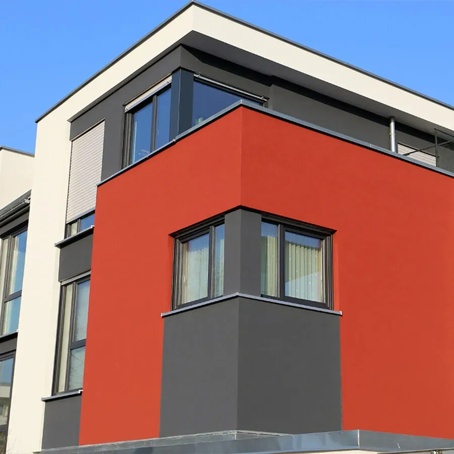 A building with a red and grey facade has a lot of windows