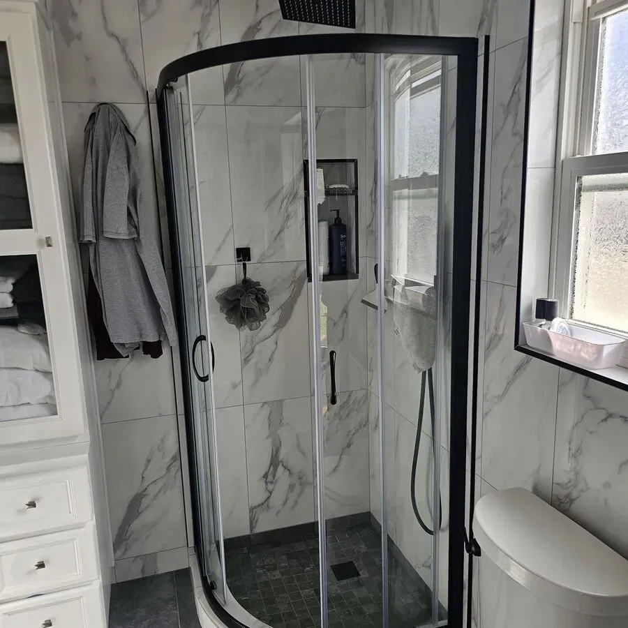 A bathroom with a walk in shower and a toilet.