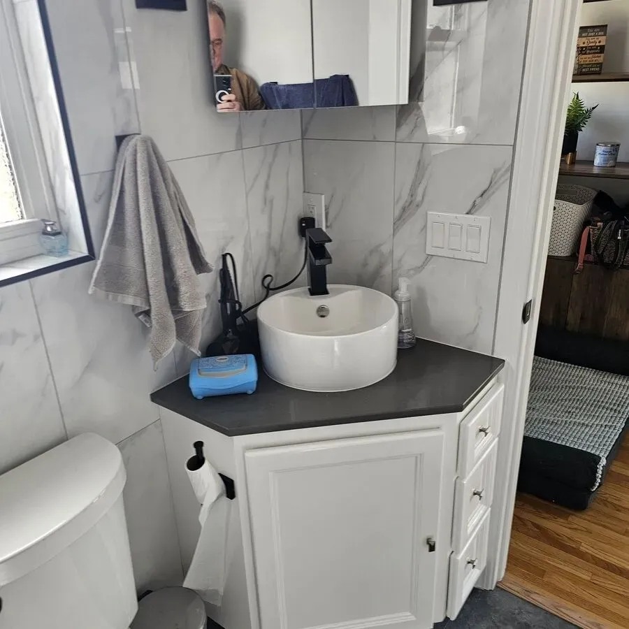 A bathroom with a sink , toilet and mirror.