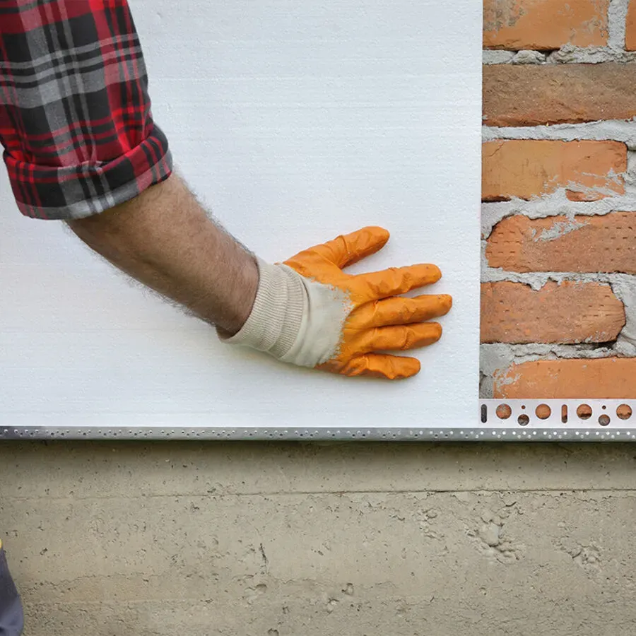 A man wearing orange gloves is touching a white board
