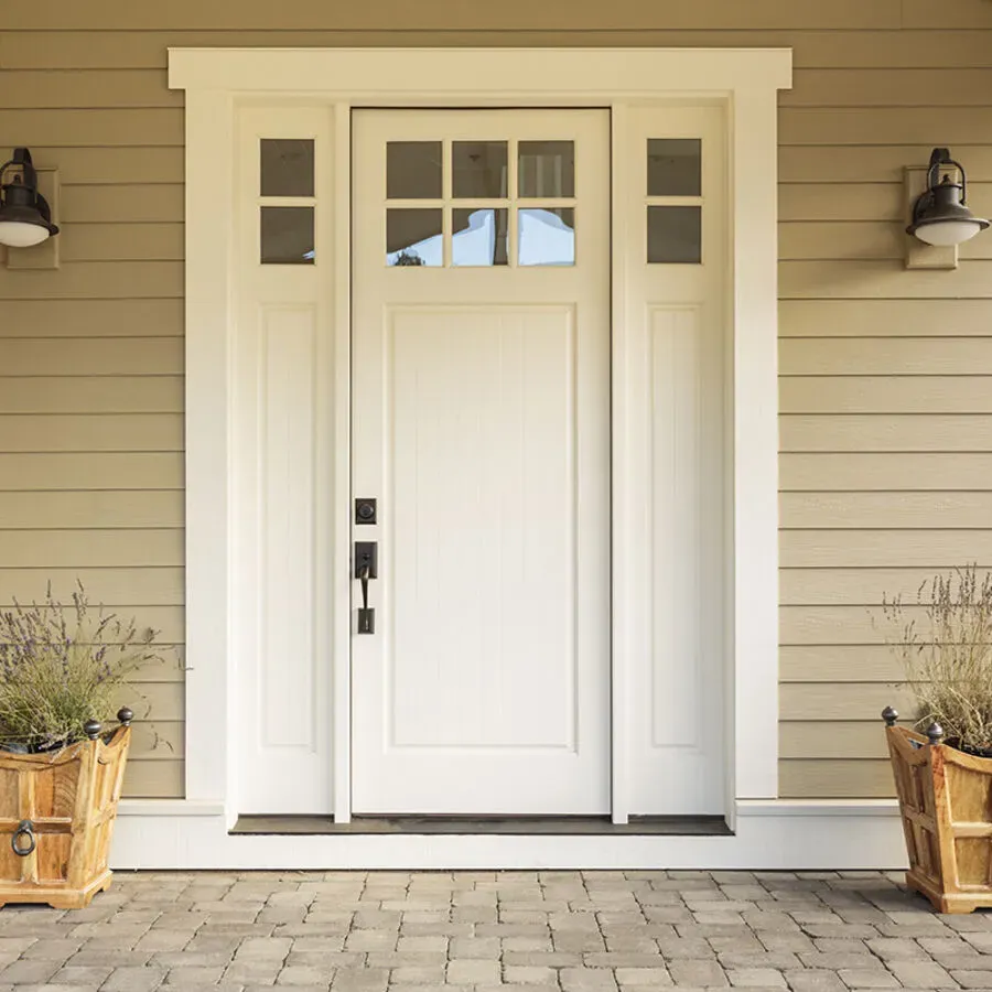 The front door of a house with two potted plants in front of it.