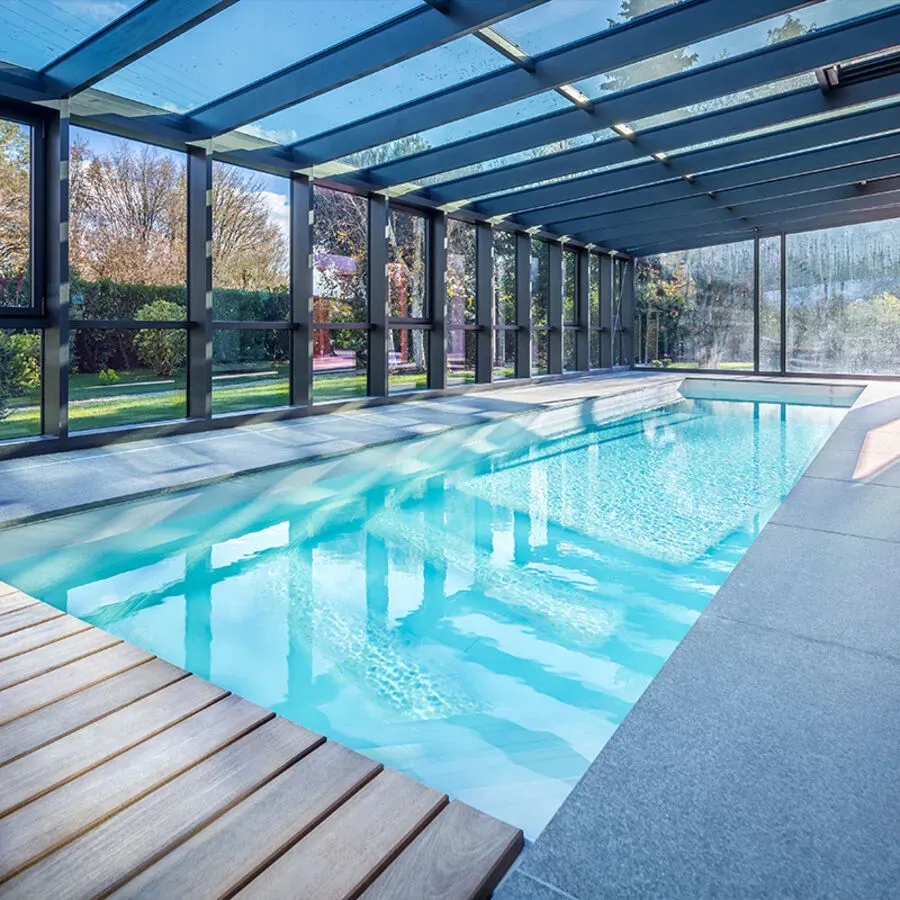 A large indoor swimming pool with a glass roof