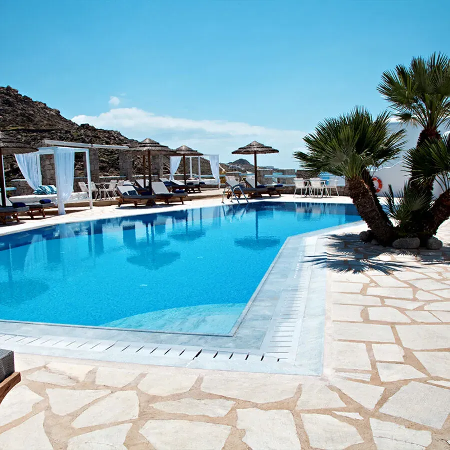 A large swimming pool surrounded by chairs and umbrellas