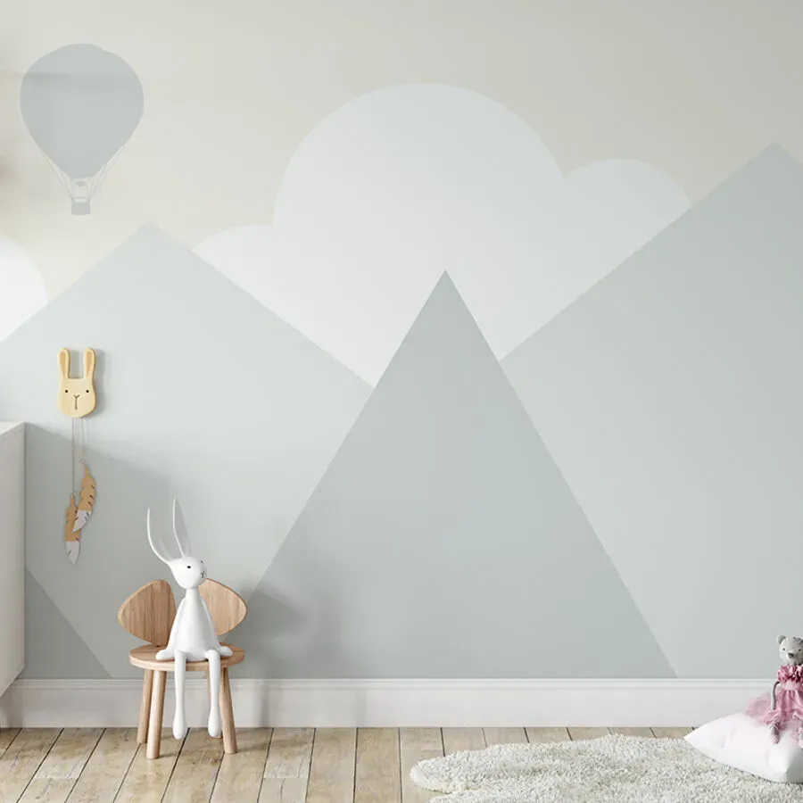 A child 's room with a painting of mountains on the wall.