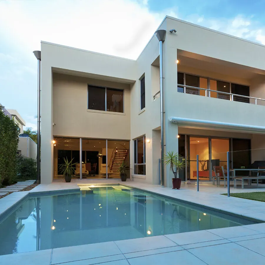 A large house with a swimming pool in front of it
