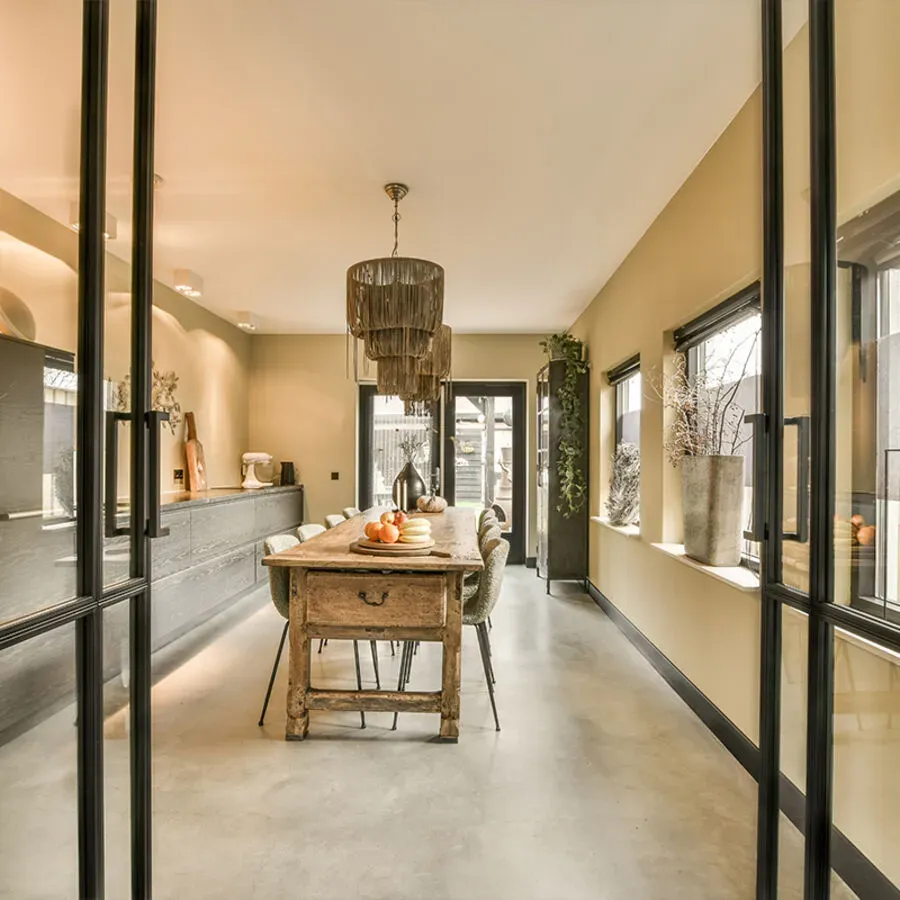 A dining room with a long wooden table and chairs
