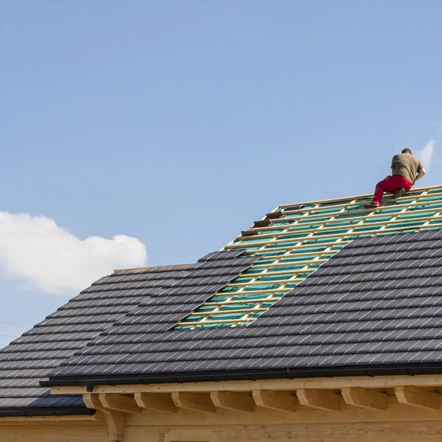 A man is working on the roof of a house