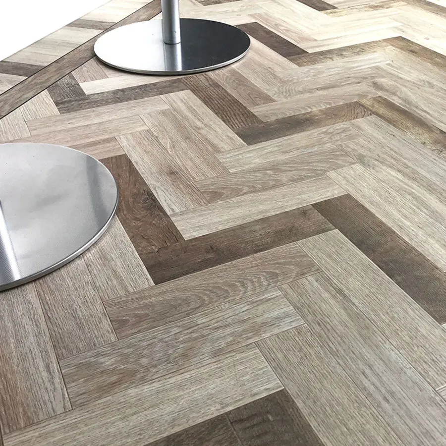 A close up of a wooden floor with a herringbone pattern.