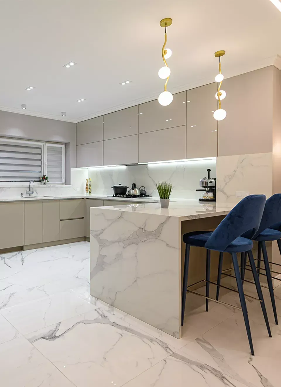 A kitchen with marble counter tops , cabinets , and stools.