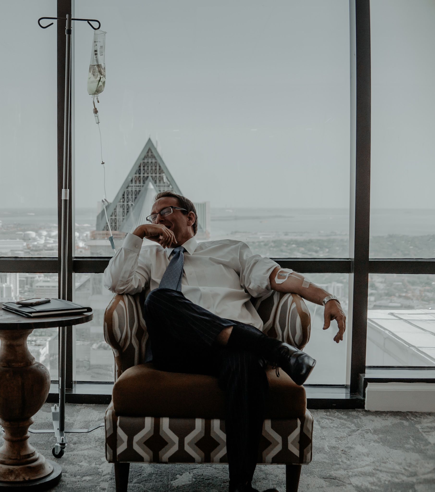 a business man in a chair with a skyscraper in the background