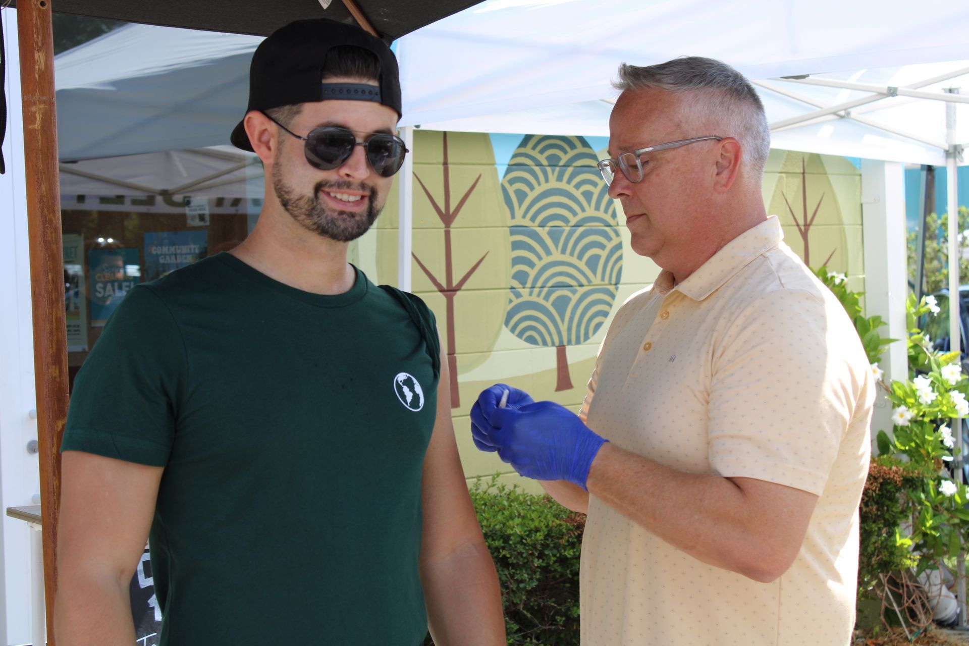 a man is getting a vaccine from another man .