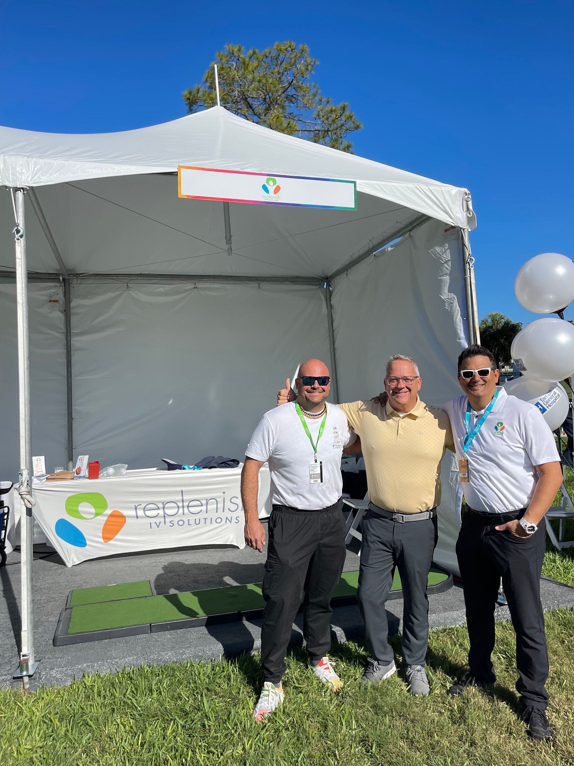 three men are posing for a picture in front of a tent .