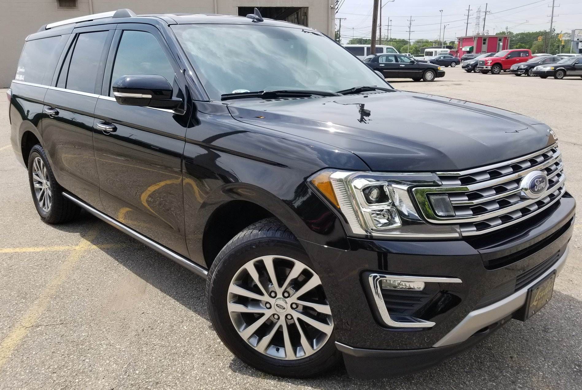 A black ford expedition is parked in a parking lot.
