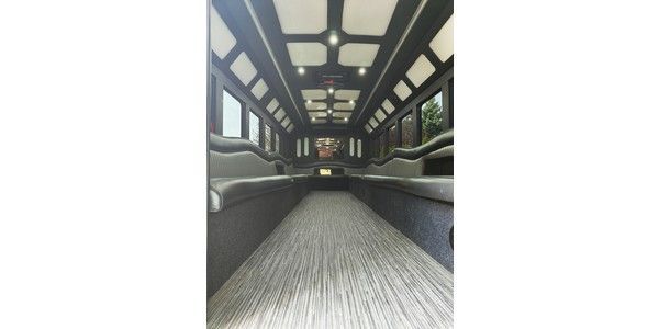 The inside of a limousine with a lot of seats and a chandelier.
