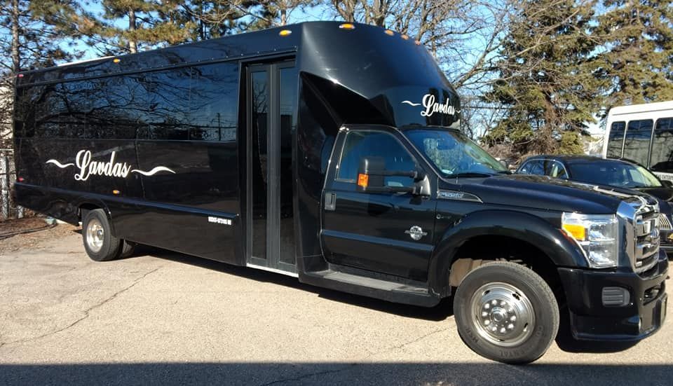 A black shuttle bus is parked on the side of the road.