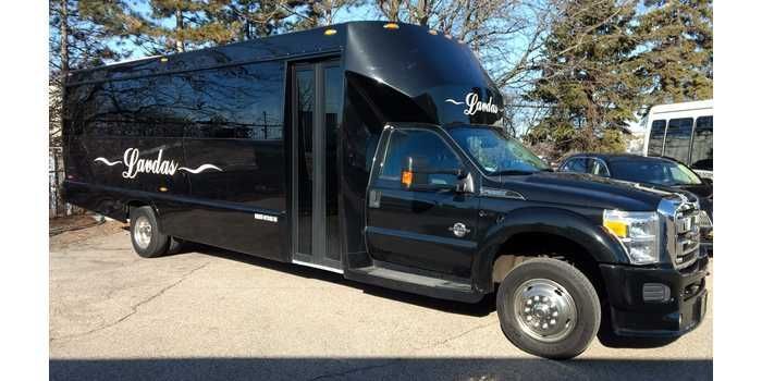 A black shuttle bus is parked on the side of the road.