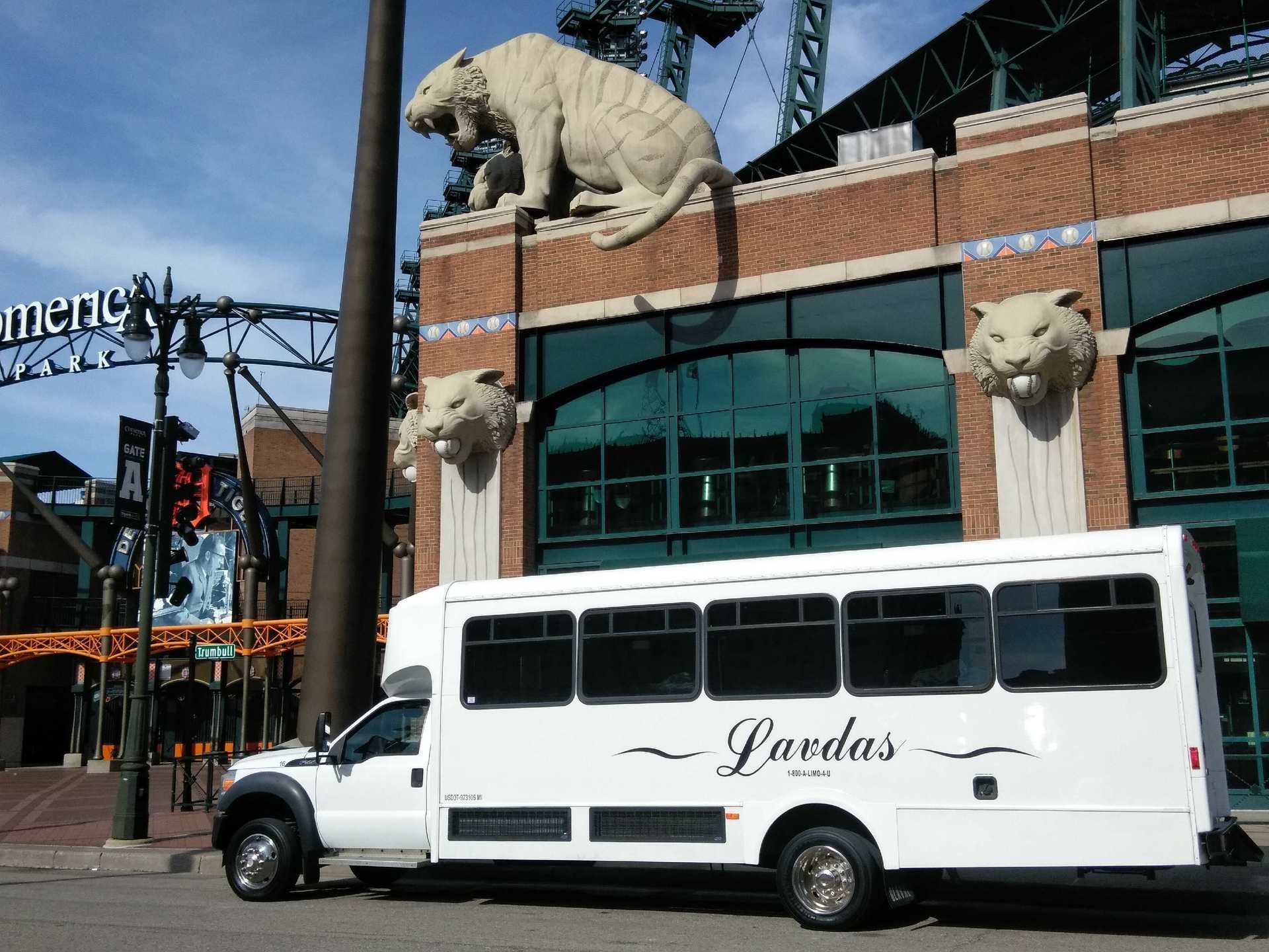 A white lavedas bus is parked in front of a building