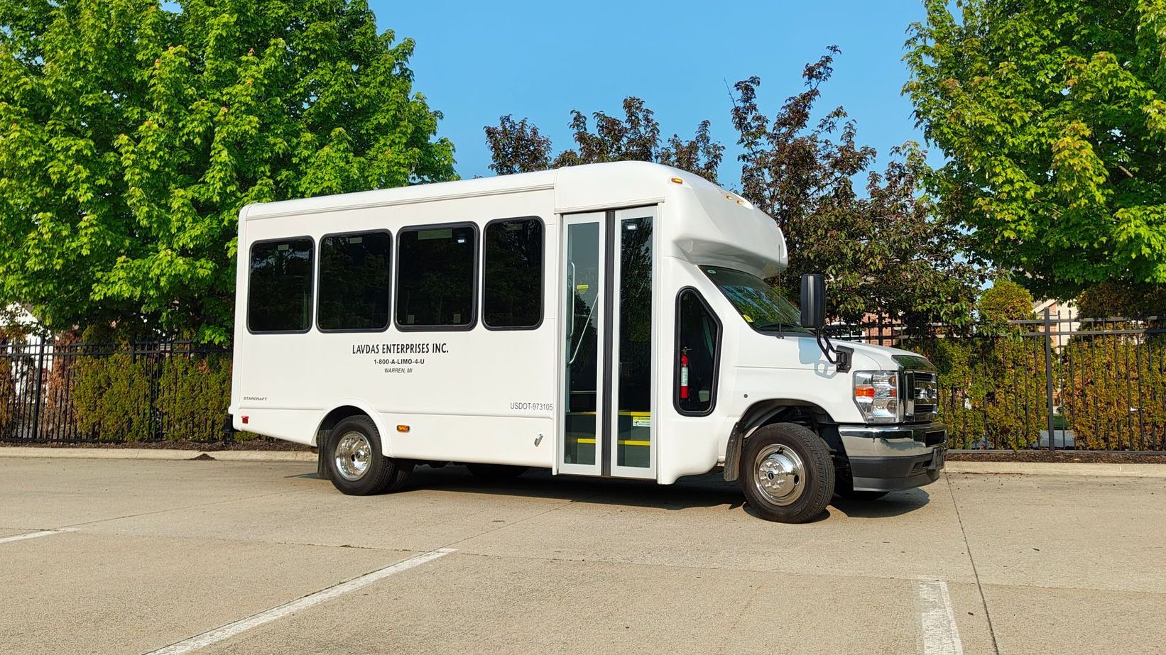 A row of buses are parked in a parking lot