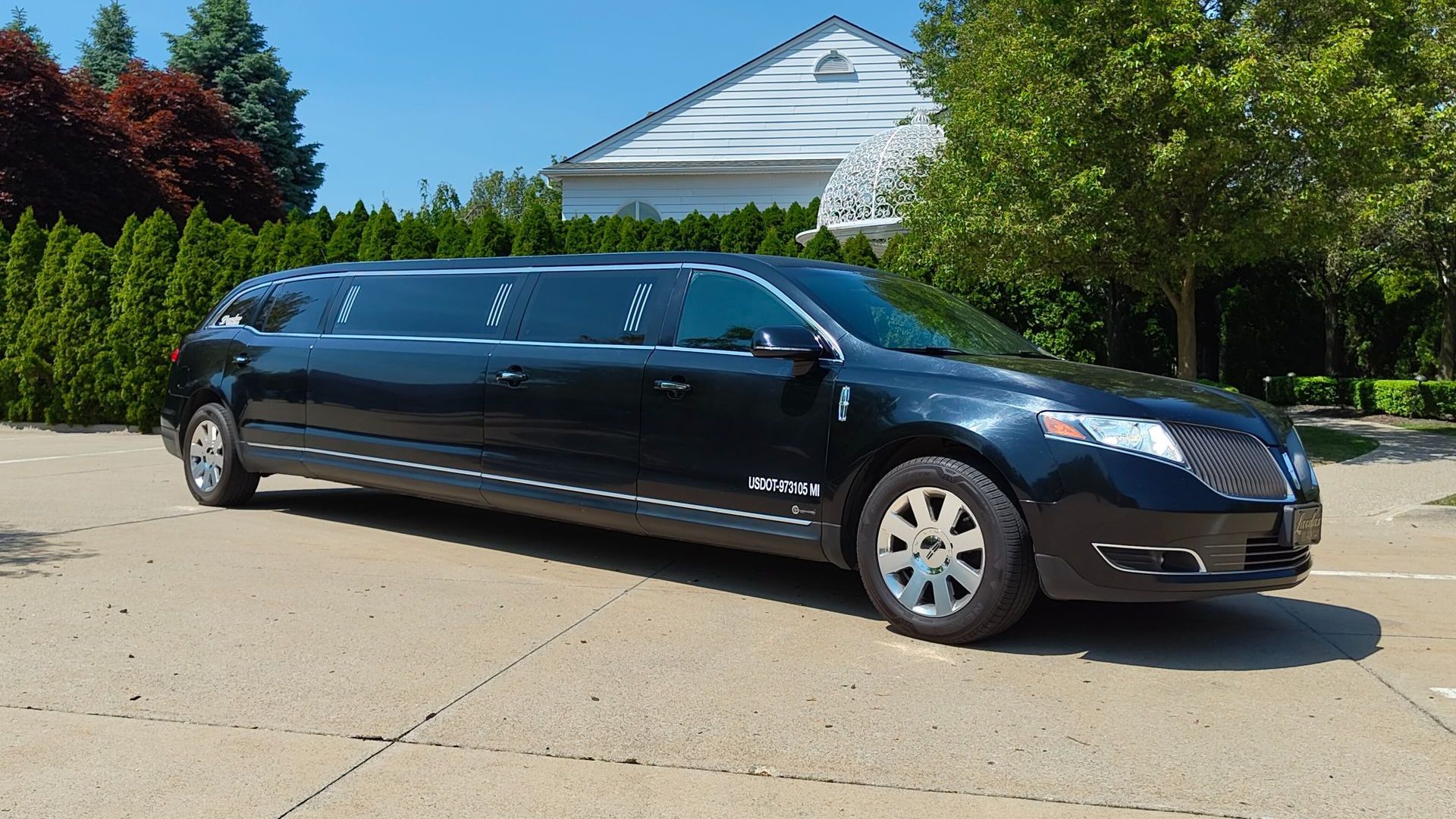 A black limousine is parked in front of a building.