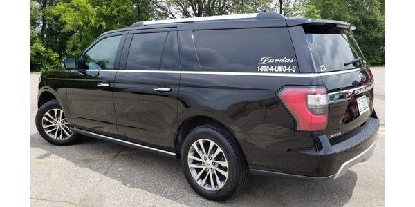 A black ford expedition is parked in a parking lot.