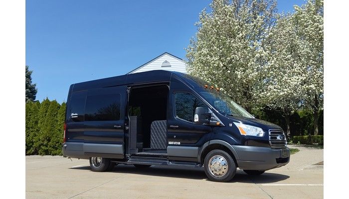 A black van is parked in a parking lot with its door open.