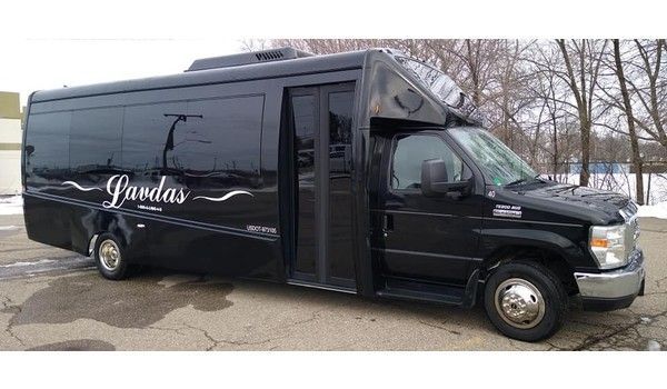 A black shuttle bus is parked on the side of the road.