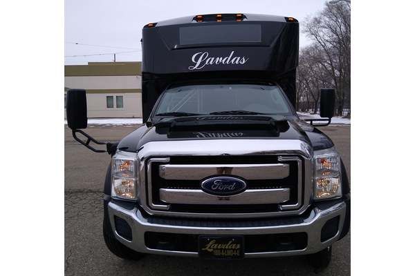 A black ford truck is parked in front of a building.