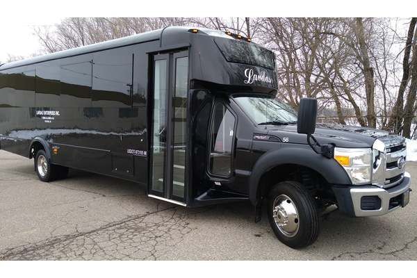 A black shuttle bus is parked on the side of the road.