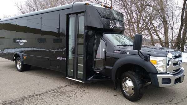 A black shuttle bus is parked on the side of the road.