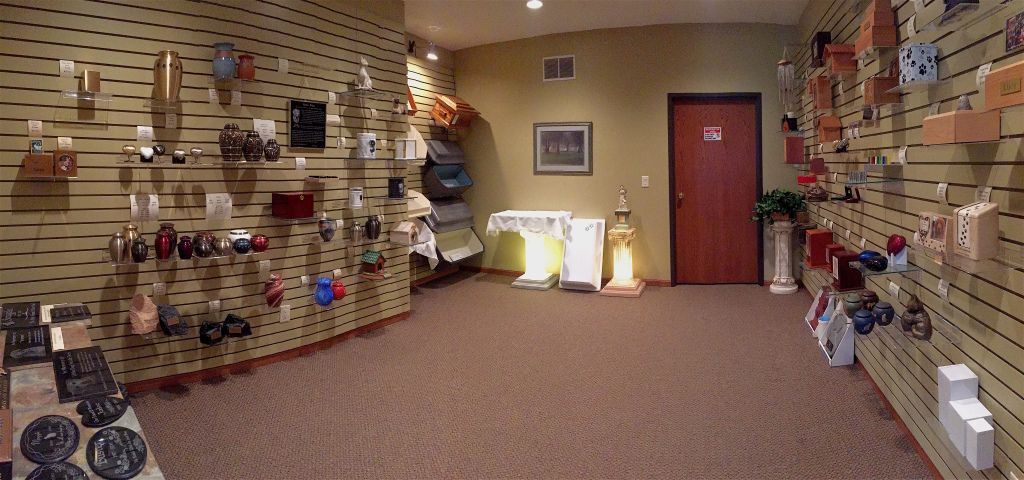 A store interior with display shelves of various items, brown carpet, and a red door.