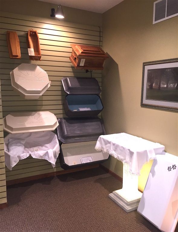 A display in a funeral home, showing urns, caskets, and tables for ceremonies.