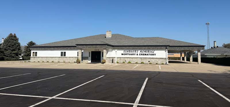 Building with sign. Parking lot in front.