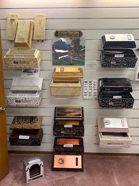 Wall display of various small urns, in a funeral home, featuring different colors and designs.