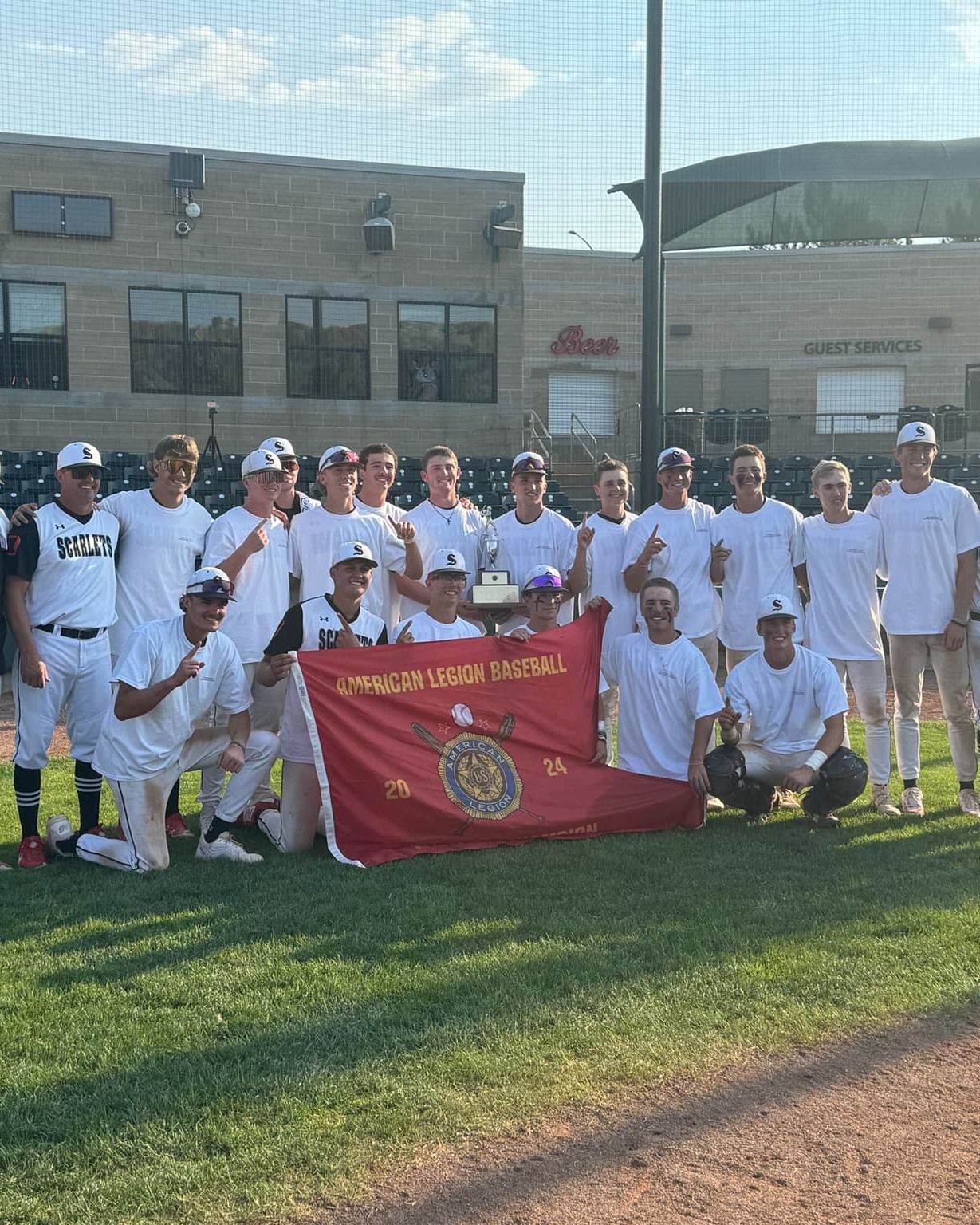 A row of athletes in protective gear aim air rifles at targets in a shooting competition.