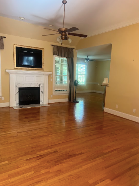 an empty living room with hardwood floors and a fireplace.