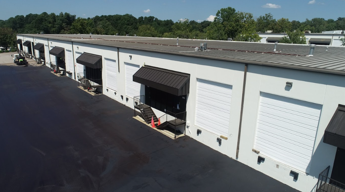 An aerial view of a warehouse with lots of doors and awnings.