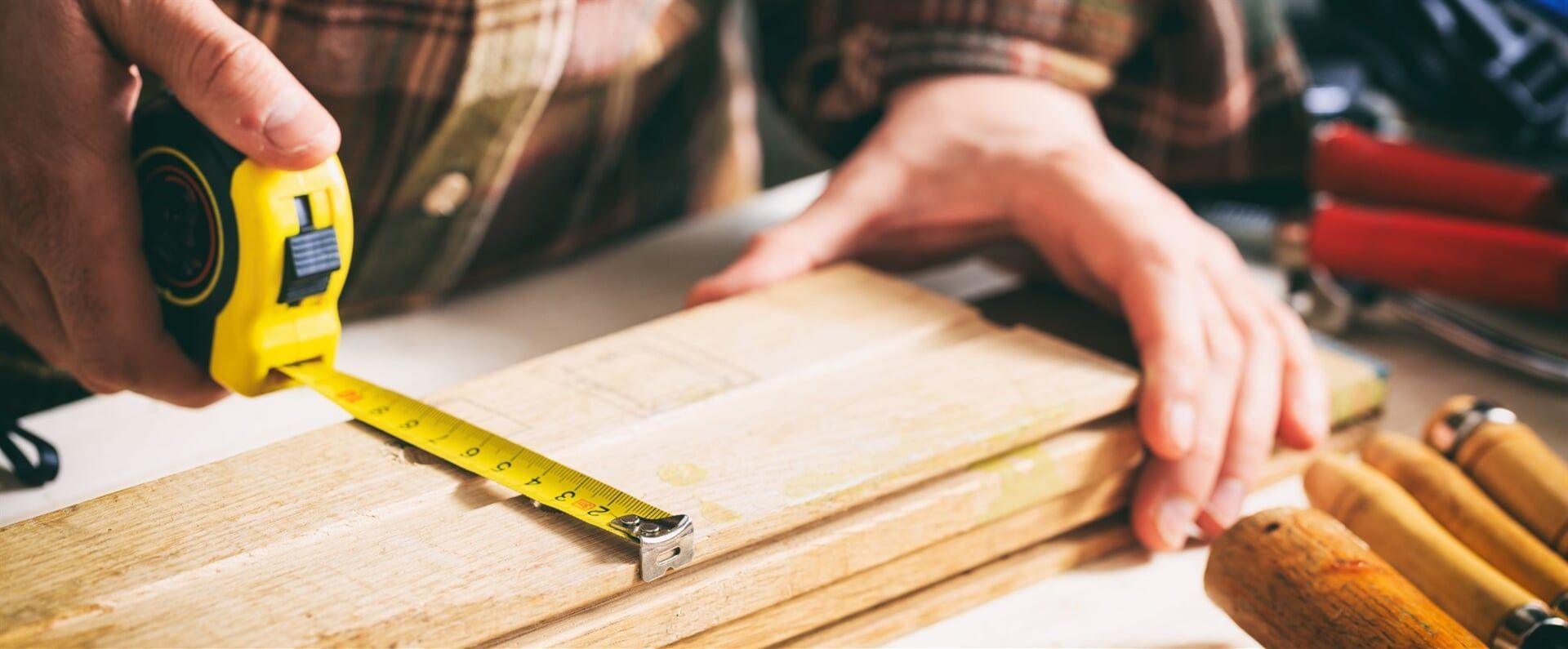 A Person is Measuring a Piece of Wood with a Tape Measure — Ken Willis Joinery Pty Ltd In South Grafton, NSW