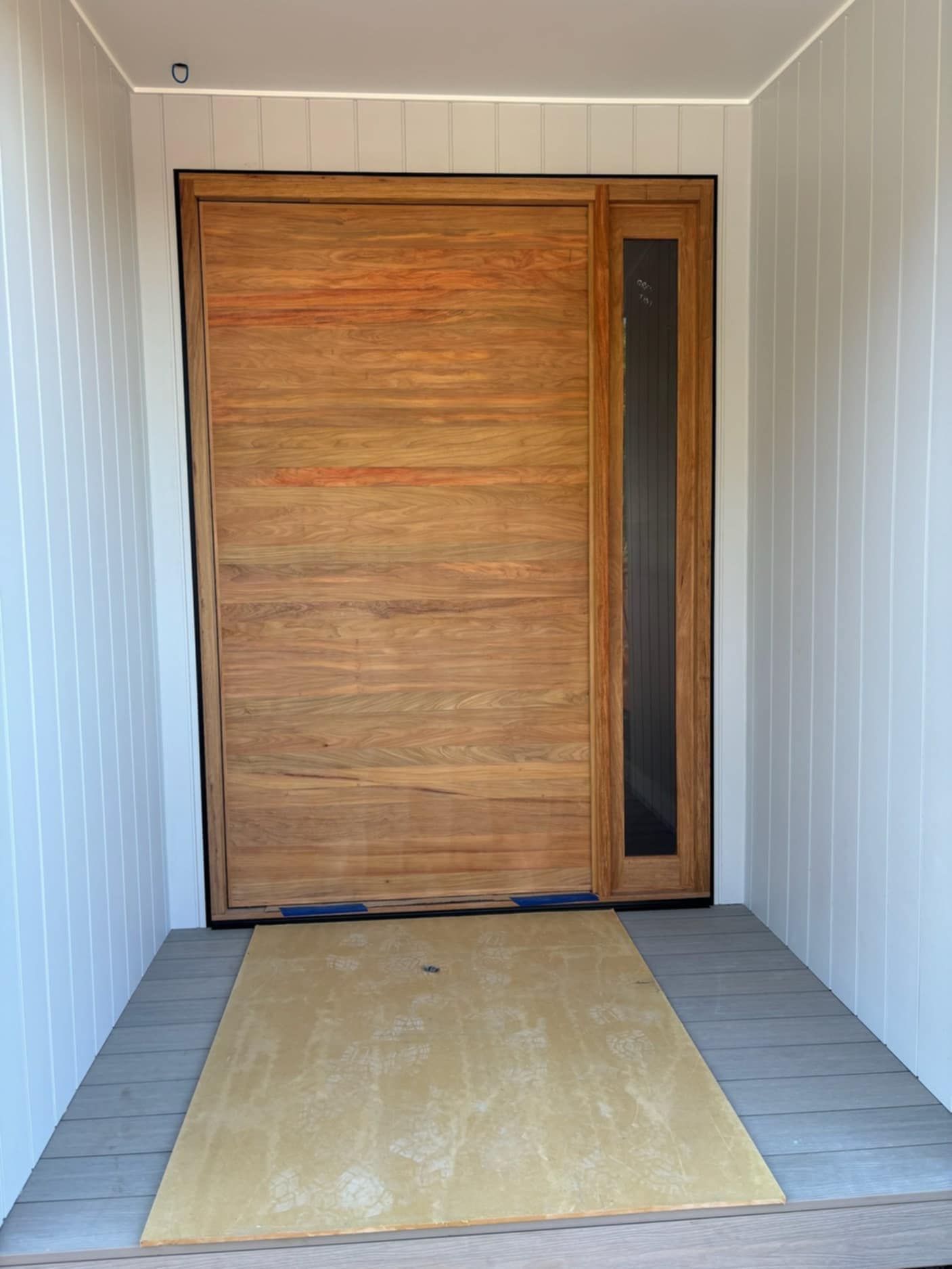 A Wooden Door With a Glass Window is in a Hallway — Ken Willis Joinery Pty Ltd In South Grafton, NSW