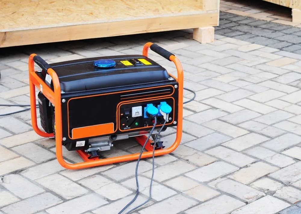 Orange and Black Portable Generator on a Brick Patio, Cords Plugged in — Wellington Mowers & Chainsaws in Wellington, NSW