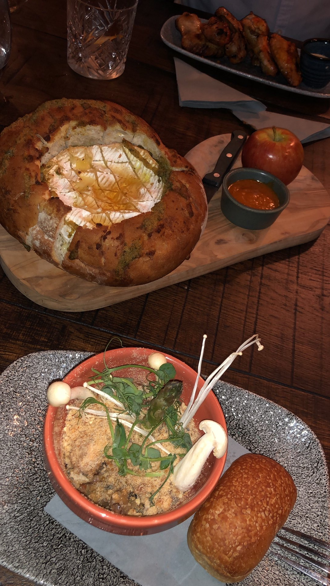 A wooden table topped with plates of food and a bowl of food.