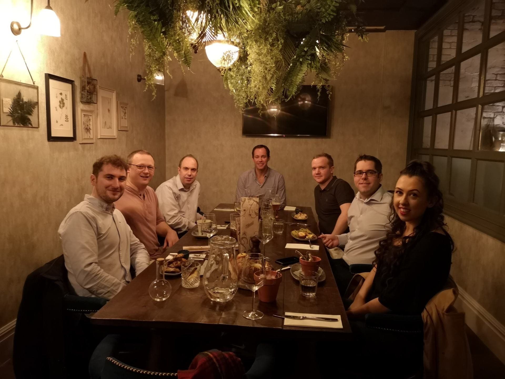 A group of people are sitting around a table in a restaurant