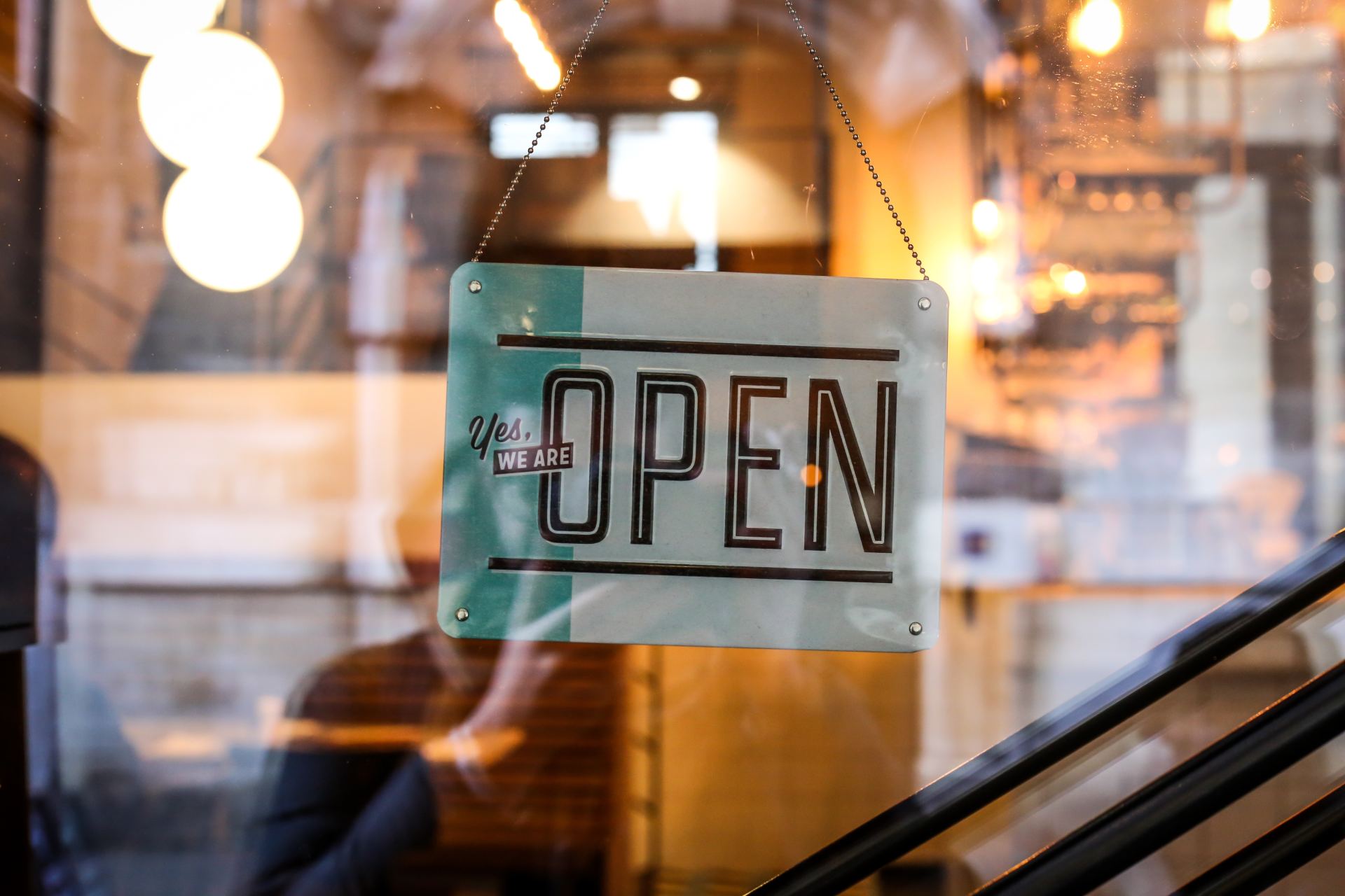 An open sign hangs on a glass door