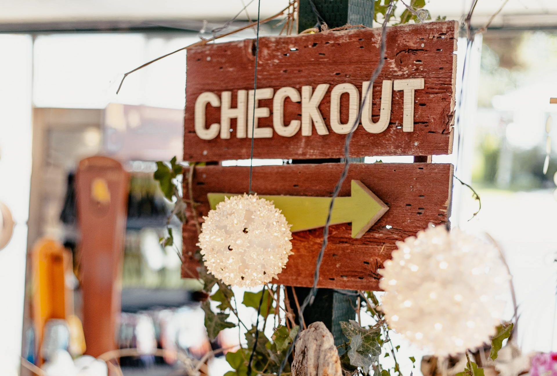 A wooden sign that says checkout with an arrow pointing to the right