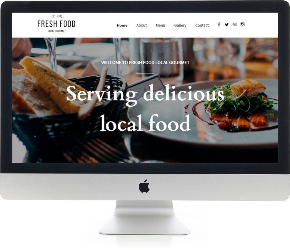 A computer monitor is displaying a website about serving delicious local food.
